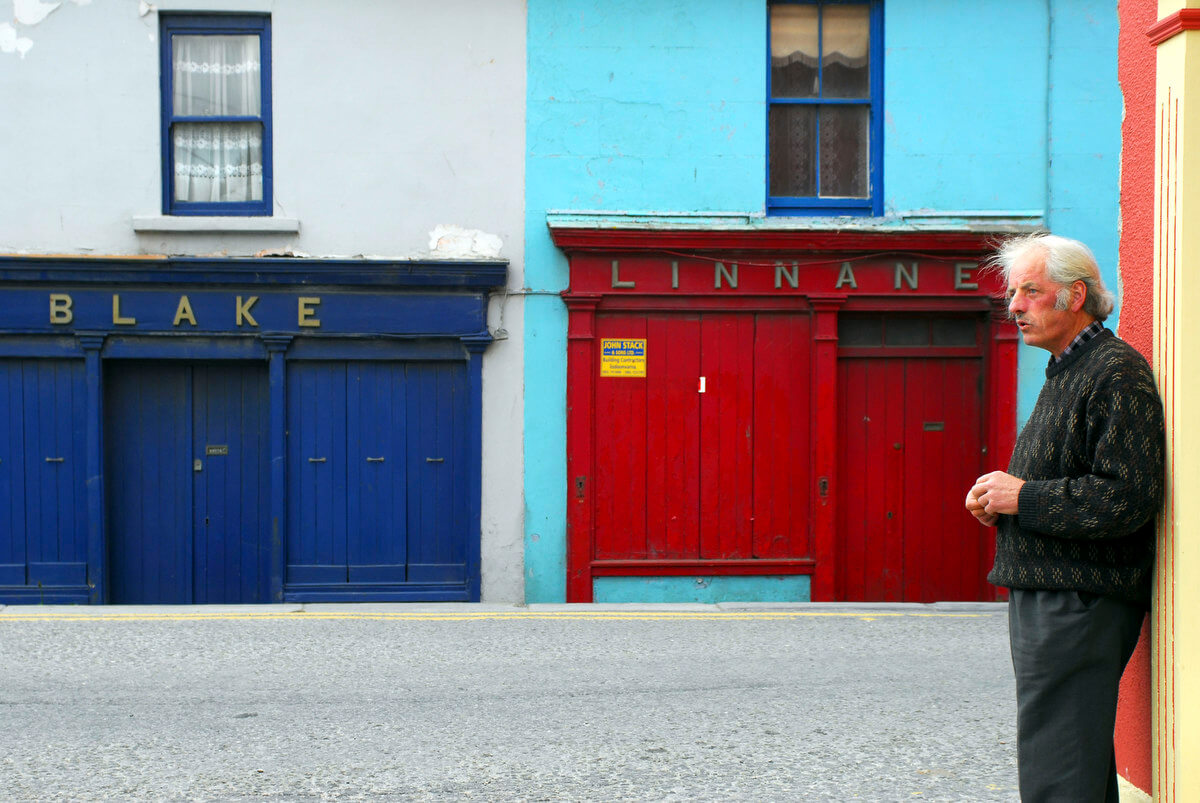 A man leaning against a wall in the centre of Lahinch.